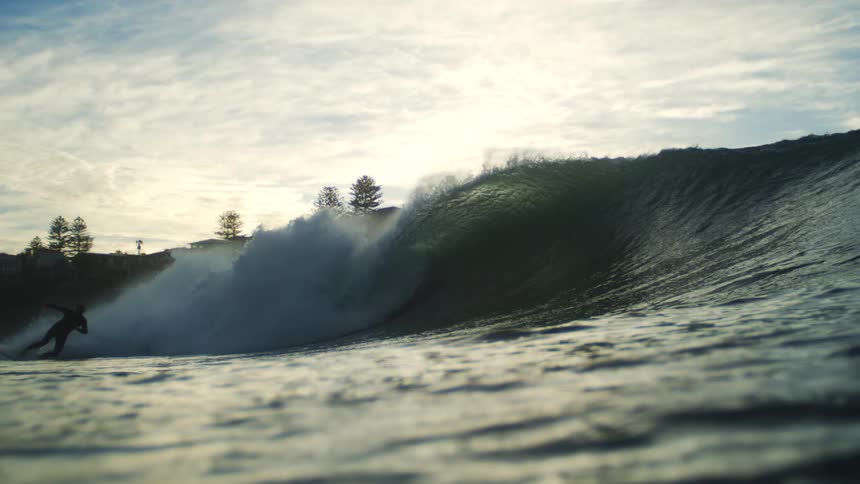 The surfer rides a wave to the shore