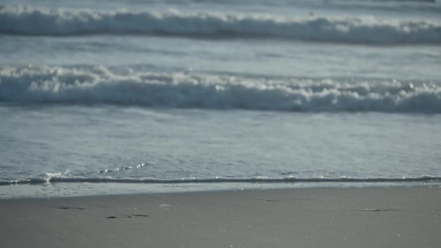 Ocean waves wash up onto a sandy beach