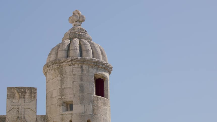 A tall tower has a window on the side