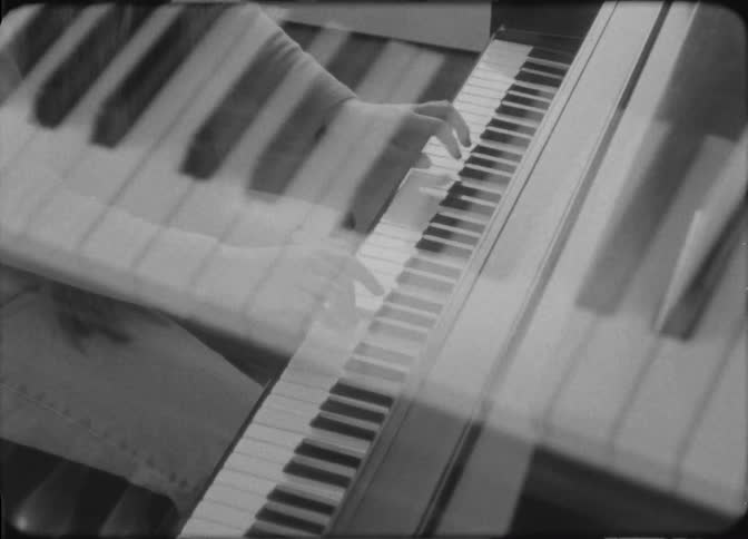 A woman is playing the piano at home