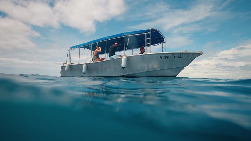 People are sitting in the boat on the ocean