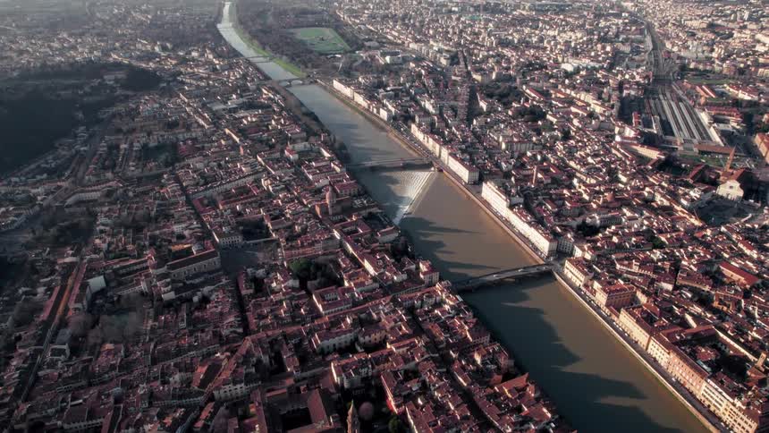 Aerial footage of a dense city with a river flowing through it