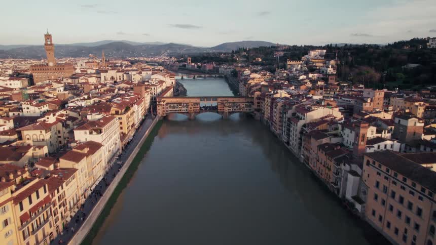 Scene of a sea canal between a classic city with mountains on the horizon