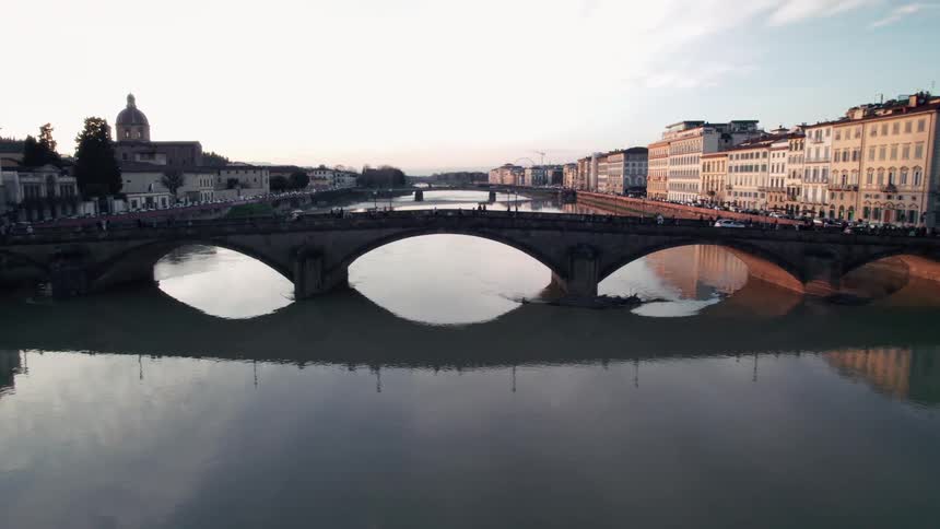People stand and walk on the bridge over the canal