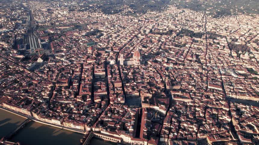 Aerial panorama of a city with the sea canal and mountains on the horizon