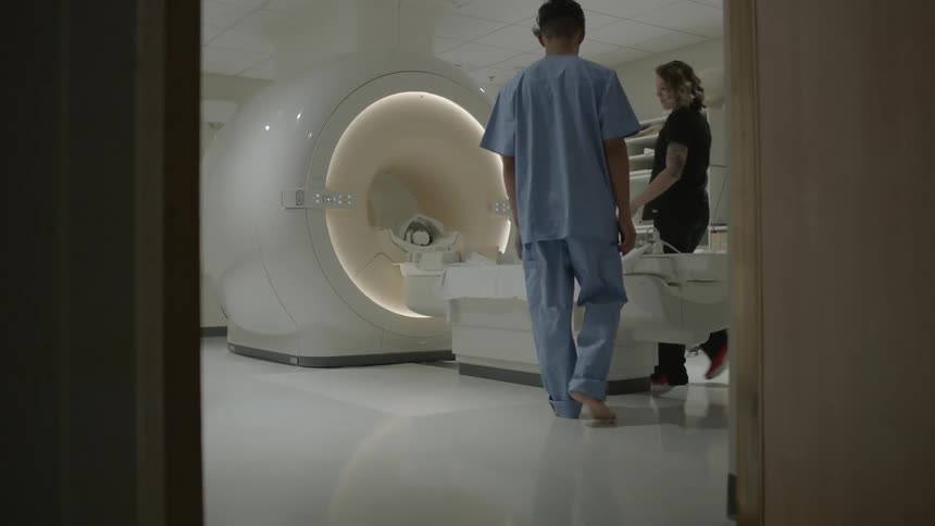 A patient approaches an mri machine in the hospital