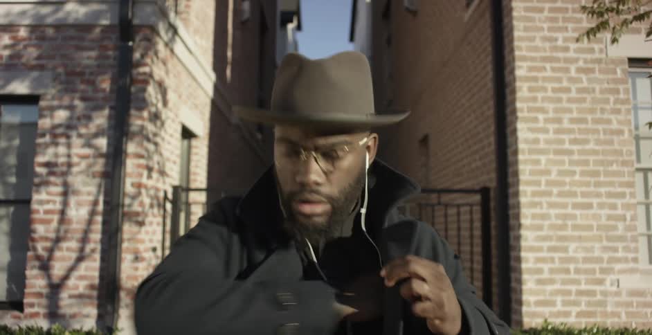 Man wearing earphones taking his phone out of his pocket