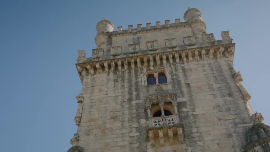 An old stone building stands against a blue sky