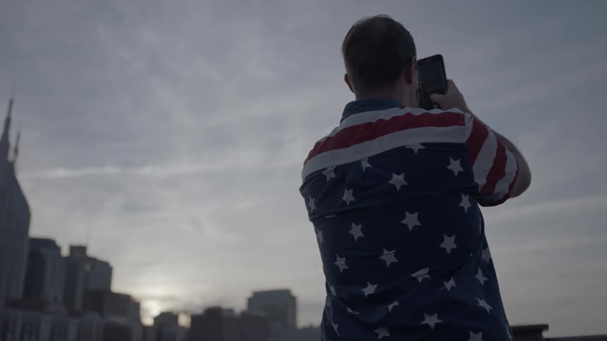 A man is taking photographs of a cloudy skyline