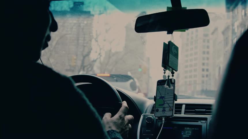 Person driving a vehicle with maps open on a smartphone