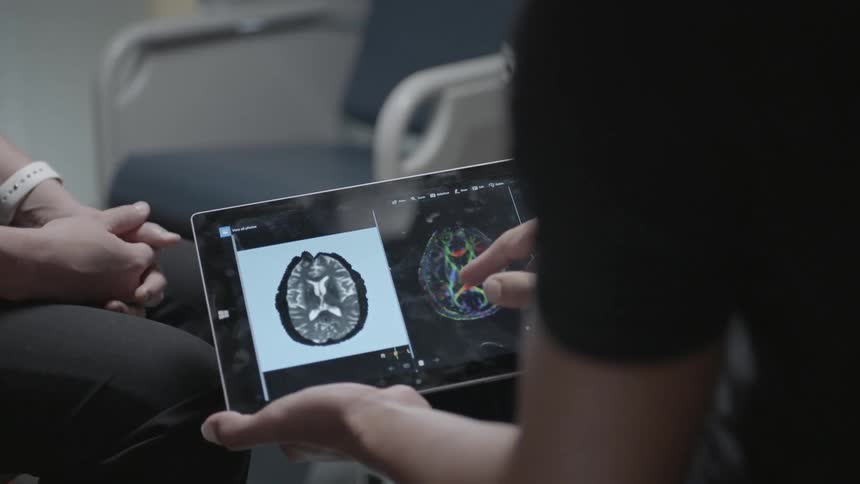 A man looks at a brain scan on a tablet