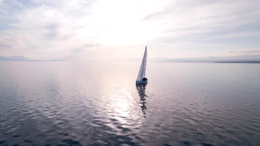A sailboat is traveling in the ocean