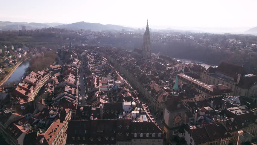 Aerial view of a historic city with a central cathedral and winding river