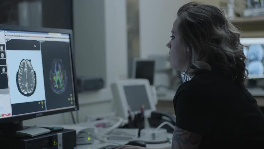 Woman looking at a computer generated image of a person's head
