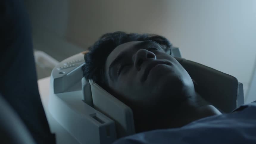 A man lays on the table of an mri machine