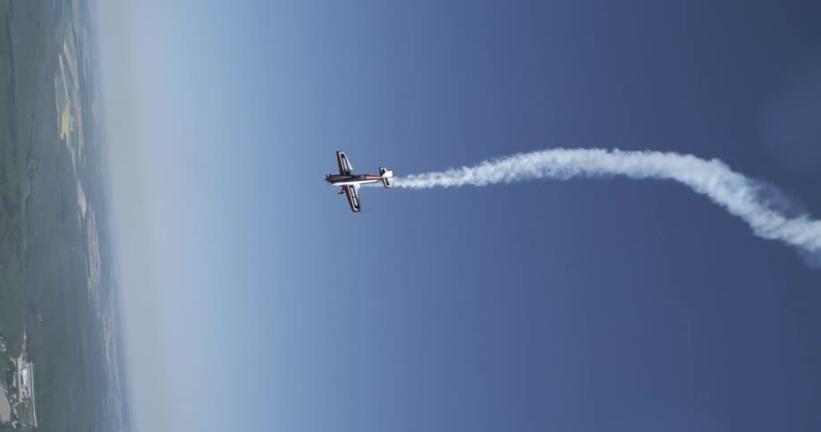 Singleengine aircraft releasing smoke and performing aerial maneuvers