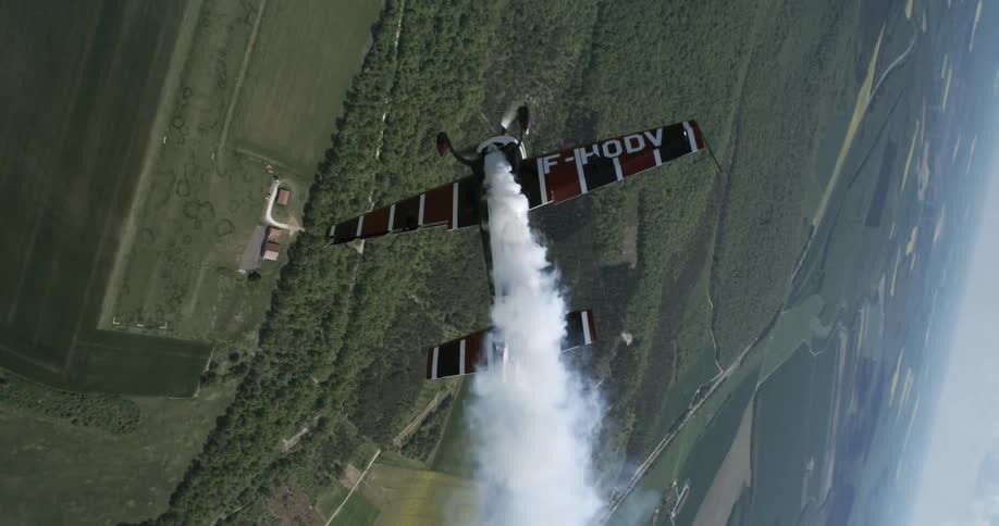 Small plane performing aerial maneuvers in a forest area
