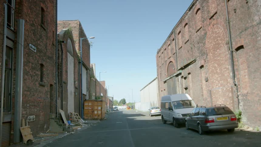 Cars and debris line a city alley