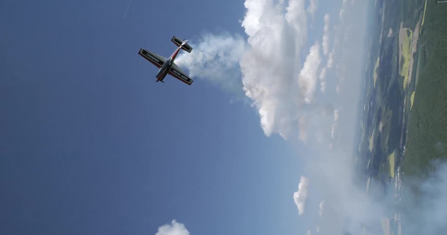 A singleengine plane is maneuvering in the sky releasing white smoke from below
