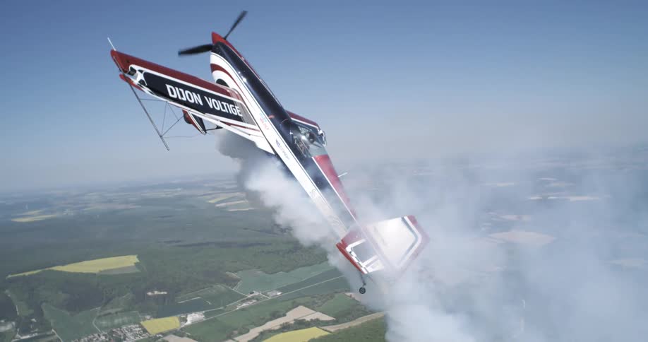 A plane struggles to fly upward as smoke pours out of the plane