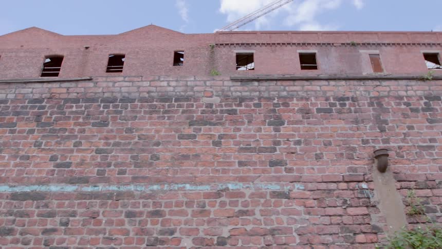 A brick wall in front of a brick building