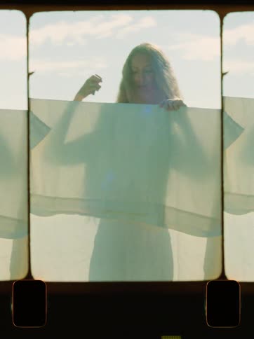 Woman putting a sheet on a clothesline