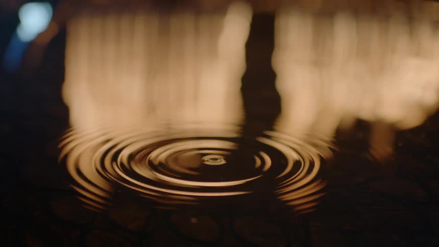 Drops of water falling into a big body of water