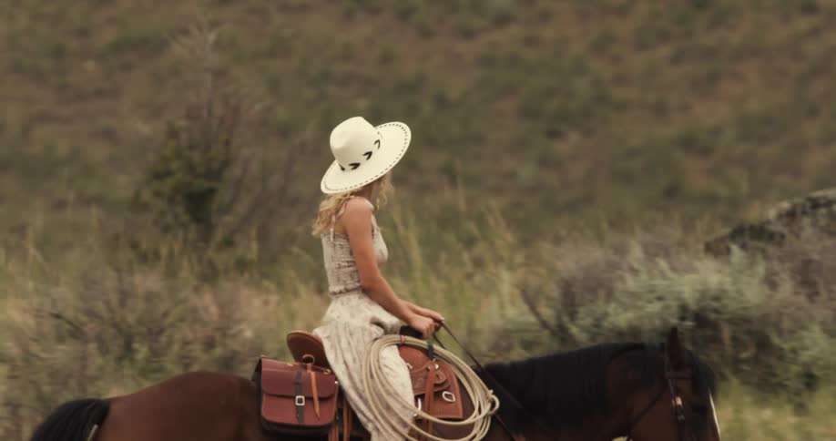 Woman and a man riding horses through the mountains