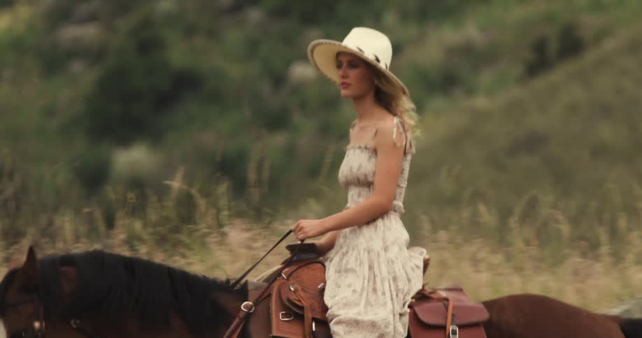 Man and woman riding horses on a mountain trail