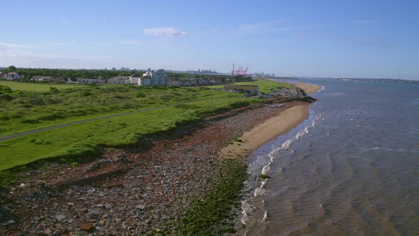 The waves crash against the shore on a sunny day