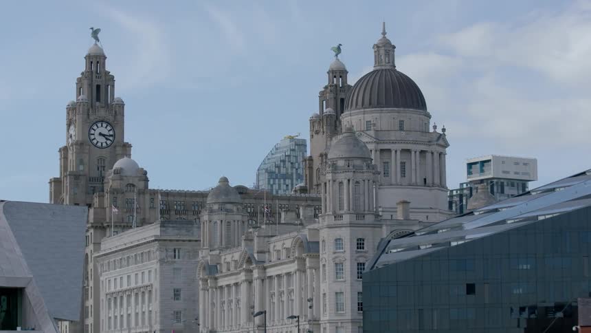 A clocktower towers into the sky around other buildings