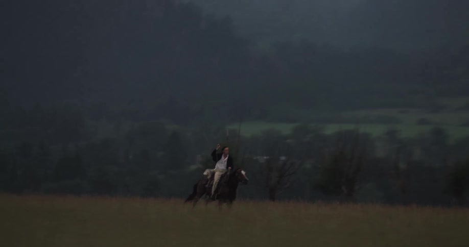 A man rides a horse through the mountains