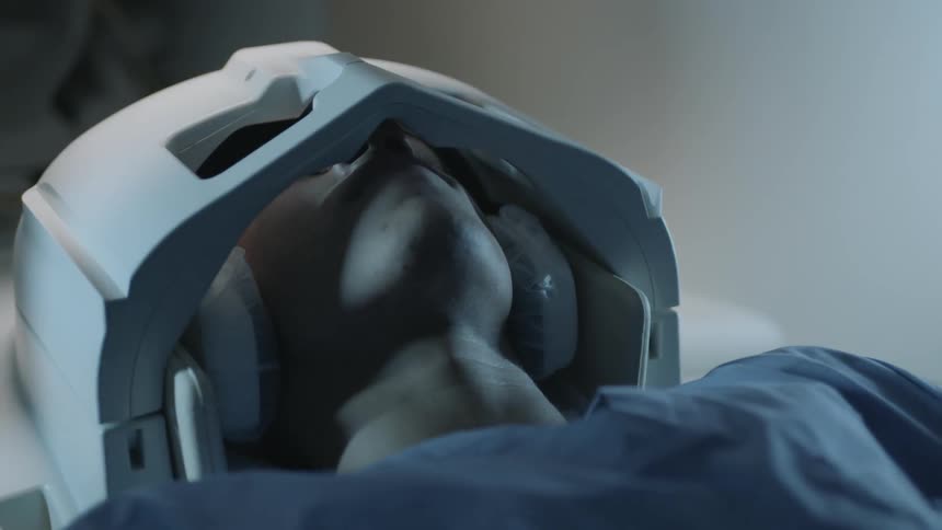 A man lays in an mri machine with his head secured