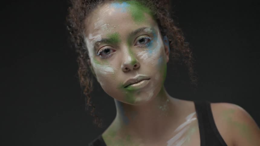 Woman with face paint looks at the camera