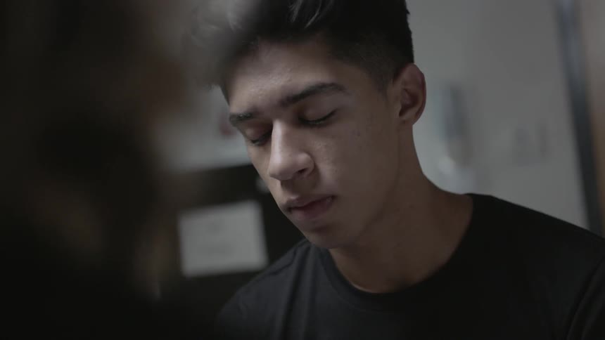 A man nods while listening to a woman speak