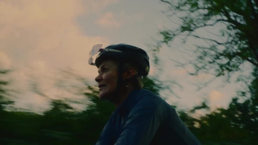Woman wearing a helmet cycling outdoors