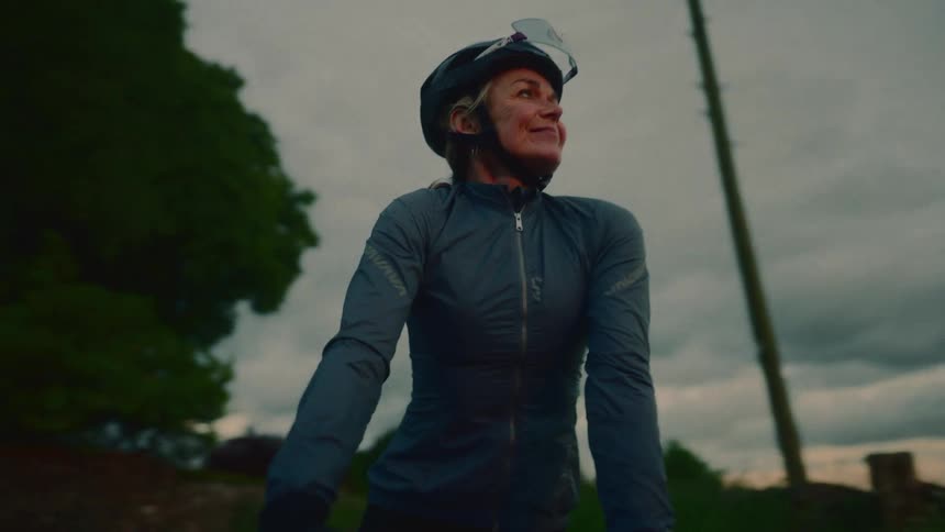 Female cyclist with excited expression in a sunrise