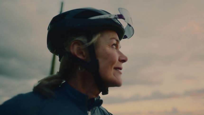 A woman is smiling as she looks at the sky