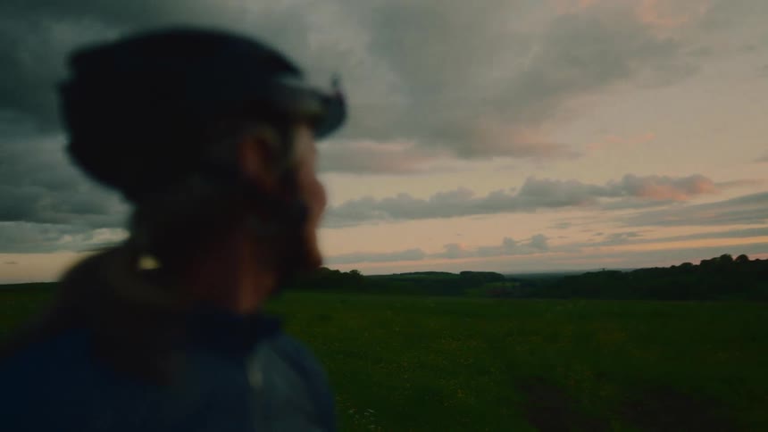 Side portrait of a woman with a cycling helmet enjoying the scenery at sunrise
