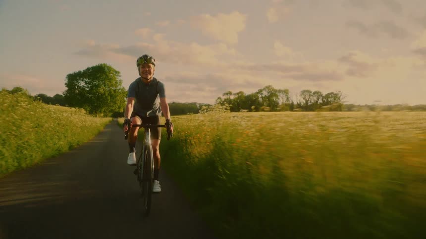 Female cyclist riding along a trail in a field