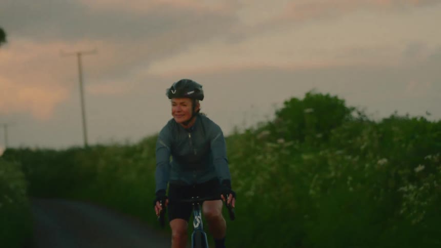 Happy cyclist riding along a wooded trail