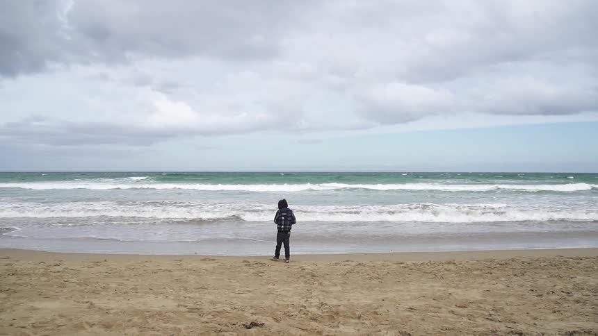 A kid standing on the beach