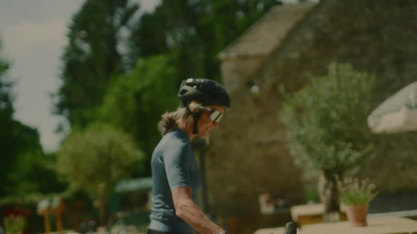 Female cyclist in sunglasses and helmet walking with her bicycle
