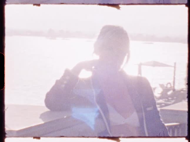 Silhouette of a woman on the seashore with reflection of the sun