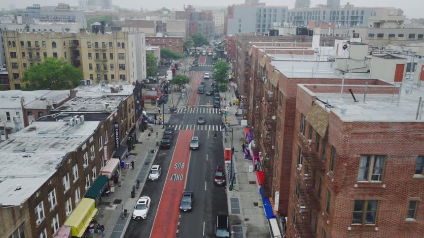 Urban street with cars buildings and a red bus lane viewed from above