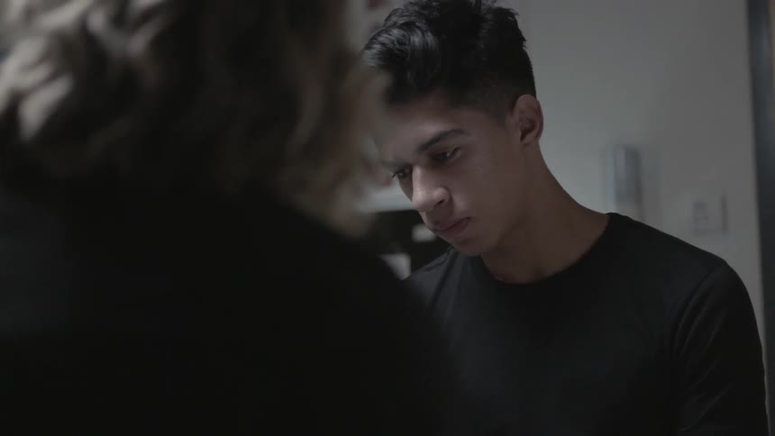 Teenager looking disappointed as a woman talks to him