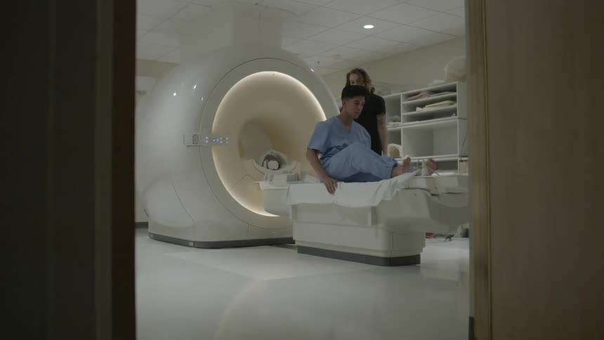 A man lays down on a table to get mri imaging done