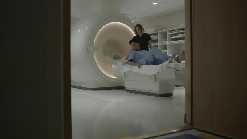A man lays down to receive an mri in the hospital