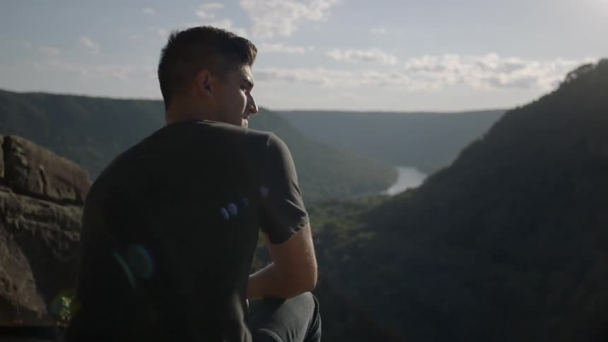 Man looks out over a wooded valley