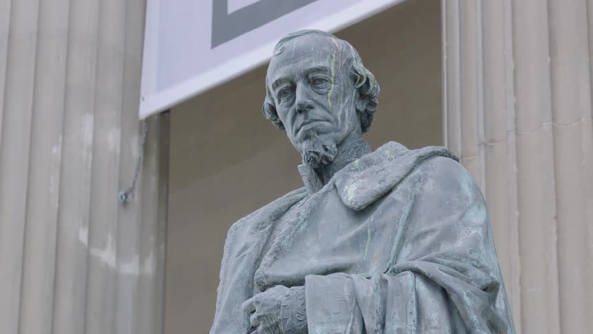Old statue outside of a building of a standing man